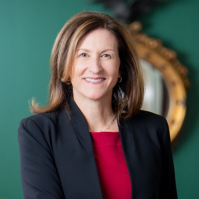 Portrait of Cheryl Venable in front of a green wall and a gold mirror