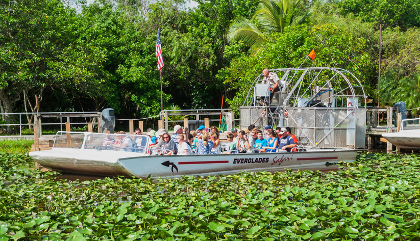 tourists ride fan boat in Florida Everglades