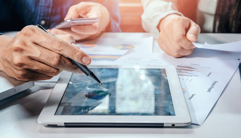 closeup of businessmen using phone and tablet on a desk