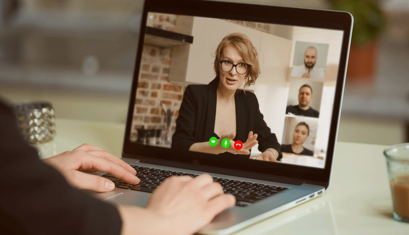 person typing on a laptop computer while participating in a video conference