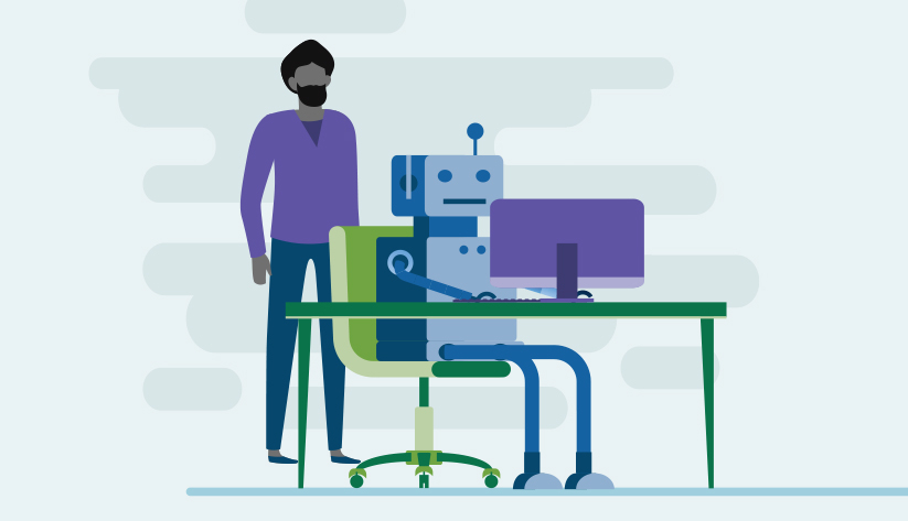 person standing behind a seated robot at a desktop computer