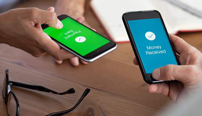 Two hands holding phones exchanging a payment