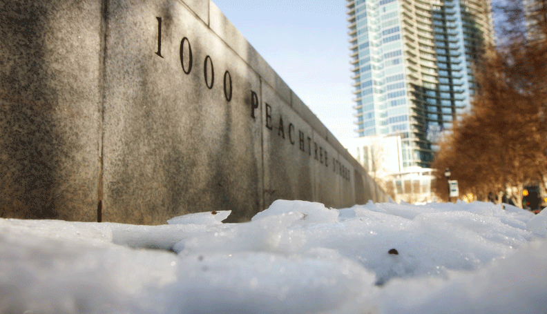View from a snow-filled sidewalk toward the marble panel engraved with the bank's street address